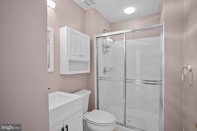 bathroom with an enclosed shower, vanity, and toilet