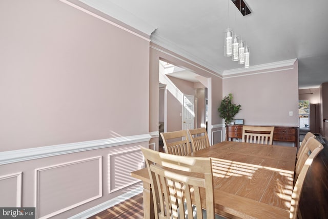 dining area featuring ornamental molding and an inviting chandelier