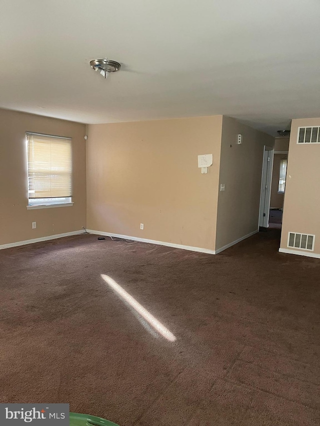 spare room featuring dark colored carpet