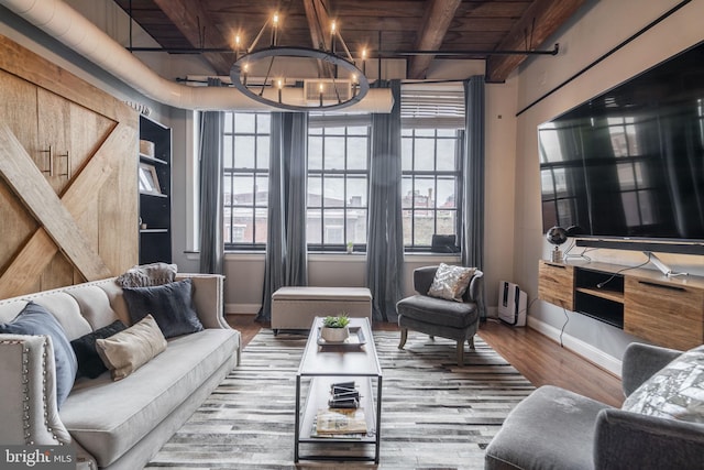 living room featuring beamed ceiling, hardwood / wood-style floors, an inviting chandelier, and wood ceiling