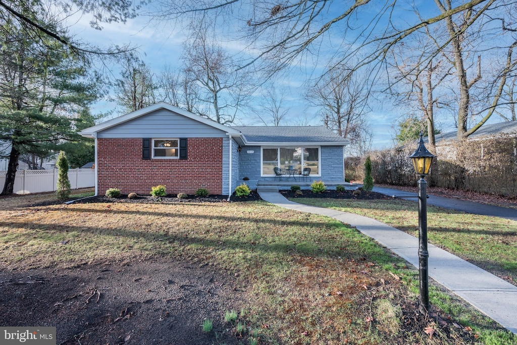 single story home featuring a front lawn