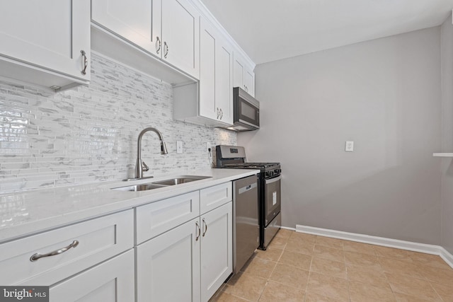 kitchen featuring white cabinets, backsplash, sink, and appliances with stainless steel finishes