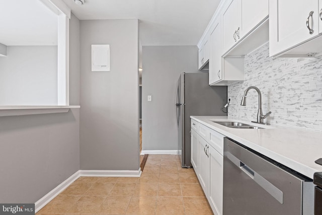 kitchen featuring sink, decorative backsplash, light tile patterned floors, appliances with stainless steel finishes, and white cabinetry