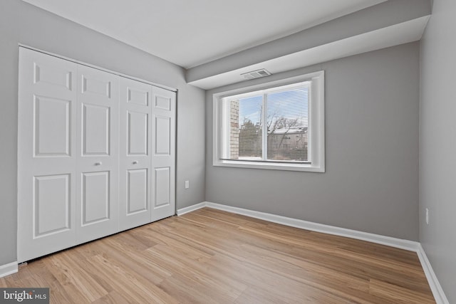 unfurnished bedroom featuring light wood-type flooring and a closet