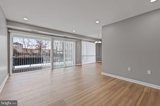 unfurnished room featuring light wood-type flooring and a chandelier