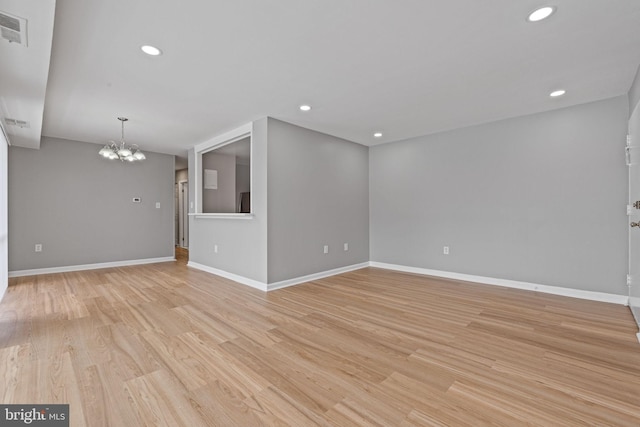 unfurnished room with light hardwood / wood-style flooring and a notable chandelier