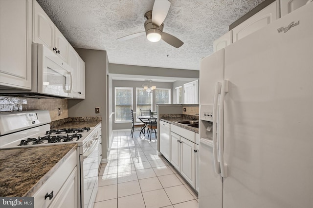 kitchen featuring ceiling fan with notable chandelier, white appliances, white cabinetry, and dark stone counters