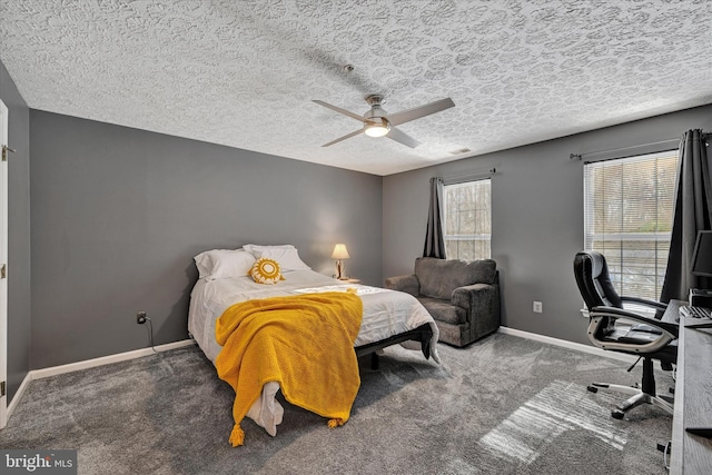 carpeted bedroom featuring ceiling fan, multiple windows, and a textured ceiling