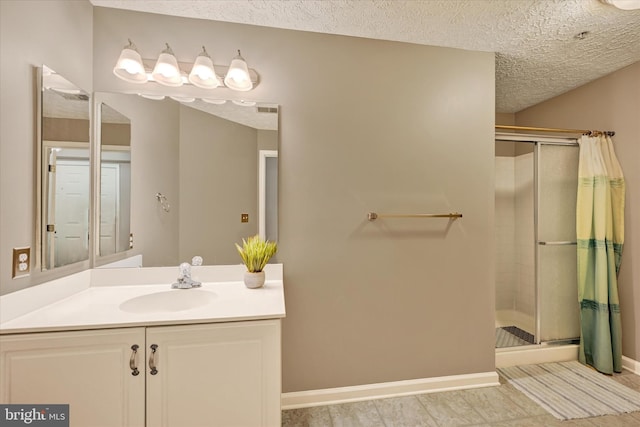 bathroom featuring a textured ceiling, walk in shower, and vanity