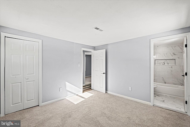 unfurnished bedroom featuring a closet, connected bathroom, and light colored carpet