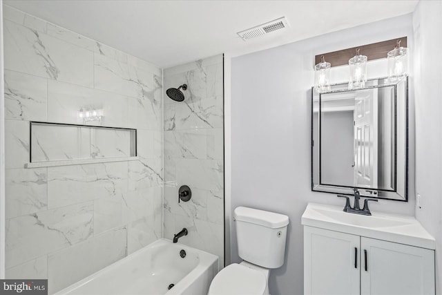 full bathroom featuring tiled shower / bath combo, toilet, and vanity