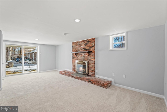 unfurnished living room featuring a fireplace, a healthy amount of sunlight, and carpet