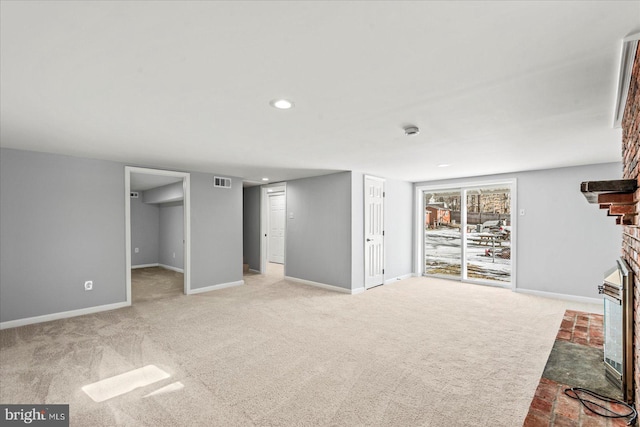 interior space featuring light carpet and a brick fireplace