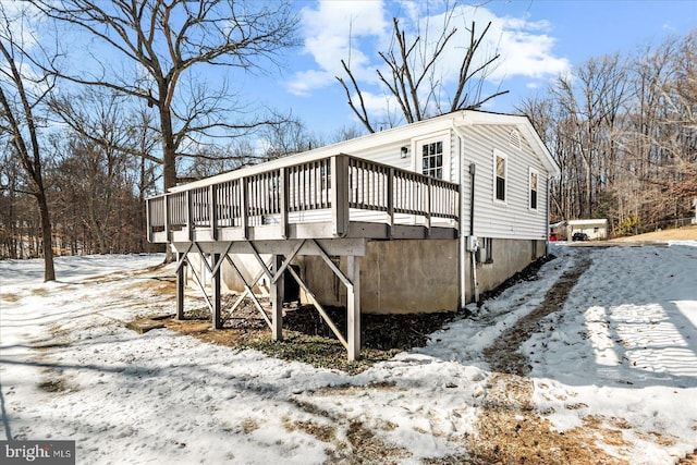 view of snow covered exterior with a deck