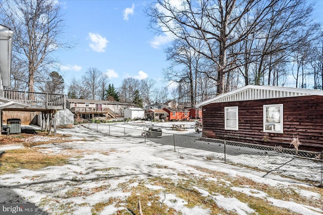 snowy yard featuring a deck and central AC unit