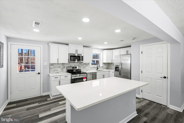 kitchen featuring white cabinetry, a center island, and appliances with stainless steel finishes