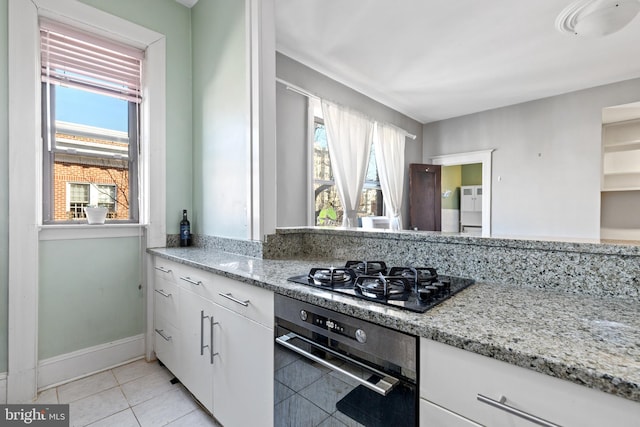 kitchen featuring light tile patterned floors, black gas cooktop, white cabinets, and wall oven