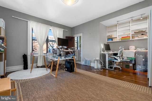 home office with track lighting, baseboards, and wood finished floors