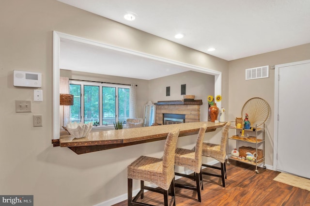 kitchen featuring a fireplace and dark hardwood / wood-style floors