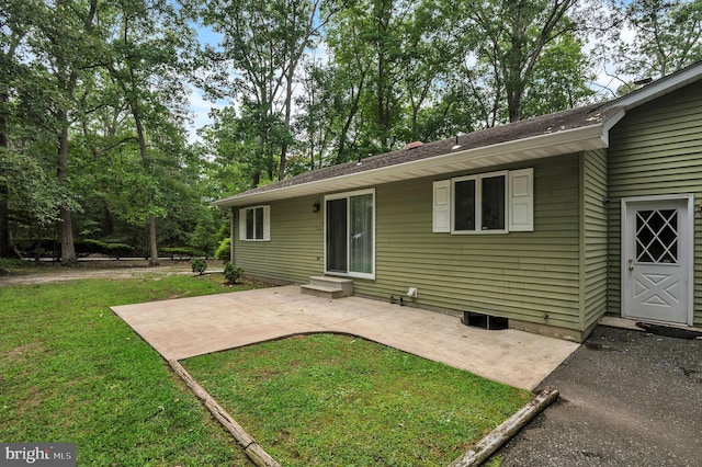 back of house with a lawn and a patio area