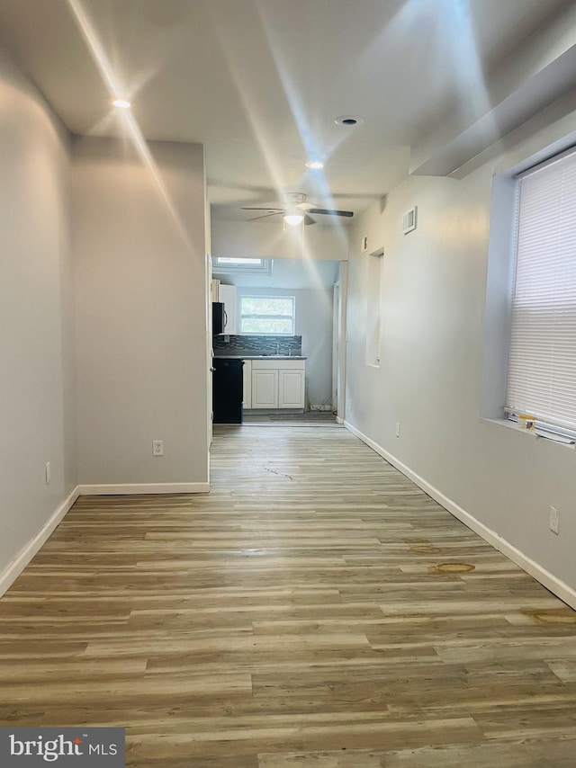 unfurnished living room featuring ceiling fan and light hardwood / wood-style flooring