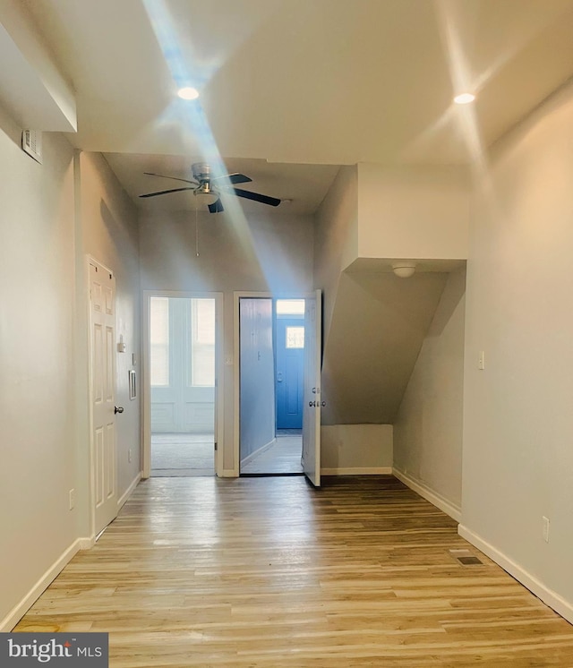 bonus room with ceiling fan, a towering ceiling, and light hardwood / wood-style flooring