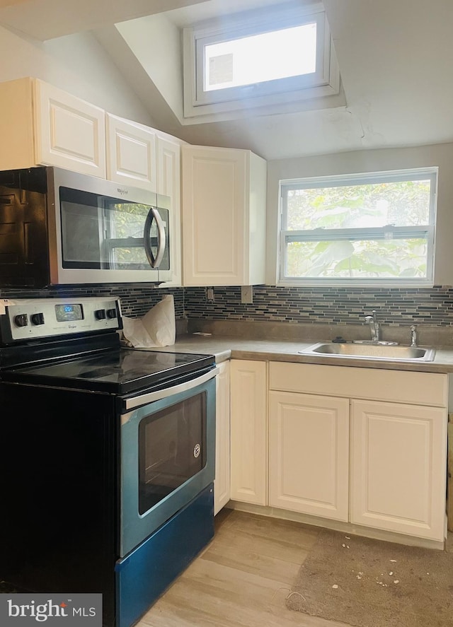 kitchen featuring white cabinets, appliances with stainless steel finishes, plenty of natural light, and sink