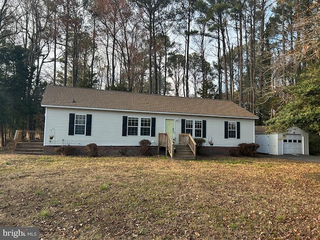 ranch-style house with a garage, an outbuilding, and a front lawn