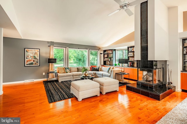 living room featuring ceiling fan, light wood-type flooring, and high vaulted ceiling