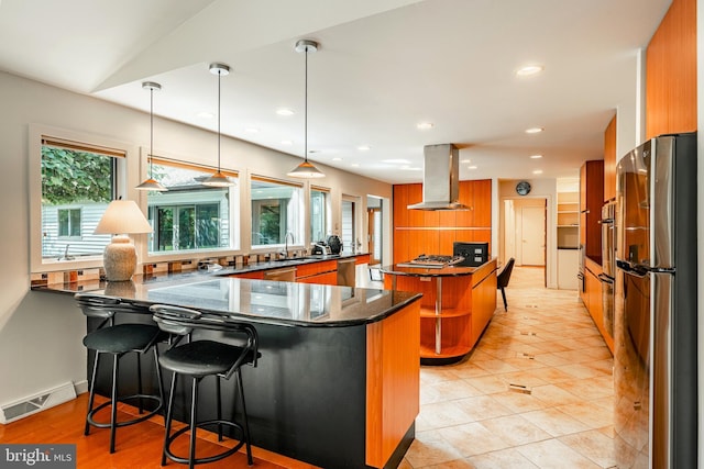 kitchen with kitchen peninsula, appliances with stainless steel finishes, a kitchen bar, extractor fan, and hanging light fixtures