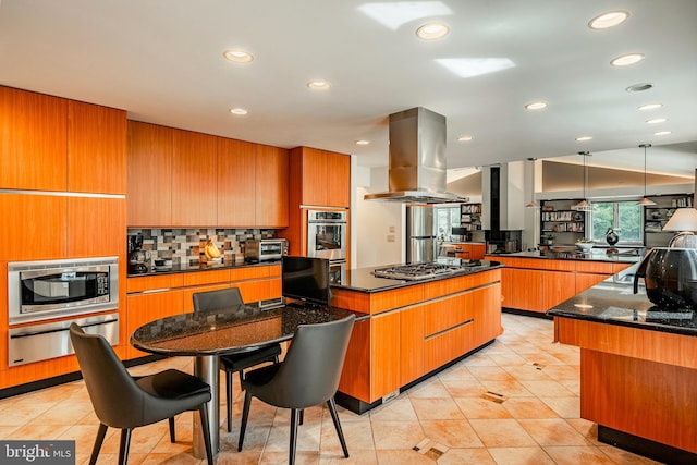 kitchen with a large island, stainless steel appliances, dark stone counters, pendant lighting, and island range hood