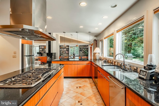 kitchen with island range hood, stainless steel appliances, dark stone countertops, and sink