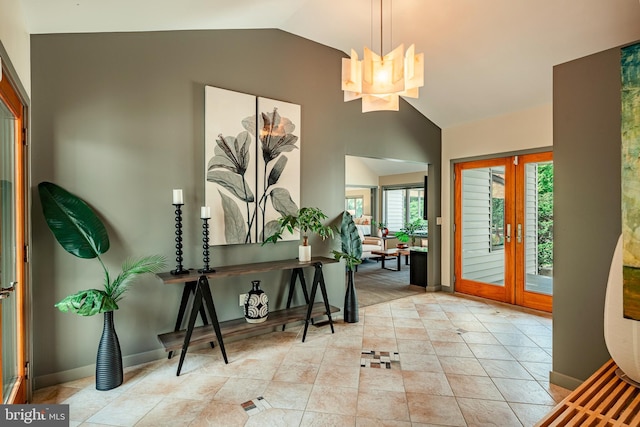 entryway featuring a notable chandelier, lofted ceiling, light tile patterned floors, and french doors