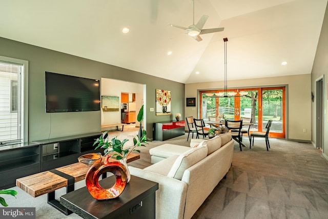 living room with a wealth of natural light, carpet floors, vaulted ceiling, and ceiling fan