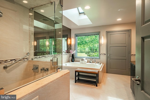 bathroom featuring a skylight, tile patterned floors, and independent shower and bath