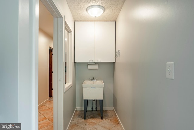 laundry room with light tile patterned floors and a textured ceiling