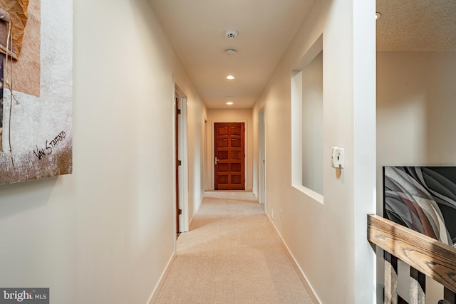 hallway featuring light carpet