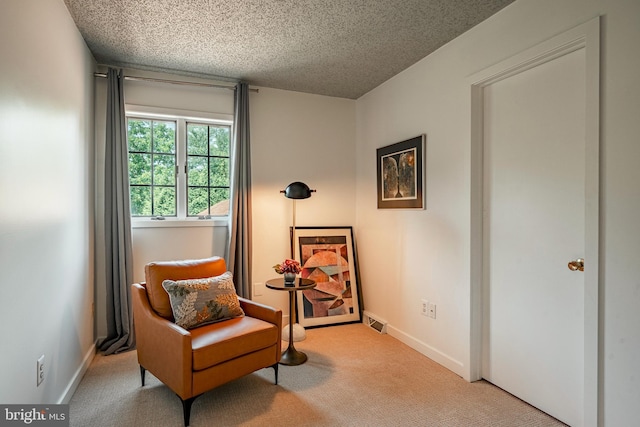 living area with light carpet and a textured ceiling