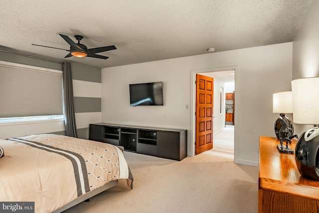 bedroom featuring light carpet, a textured ceiling, and ceiling fan