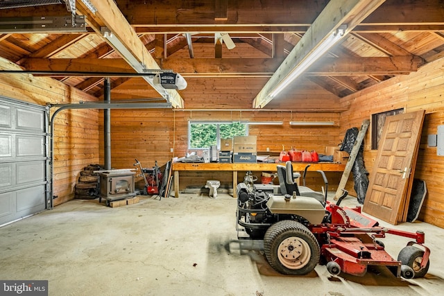 garage with a garage door opener, a wood stove, wooden walls, and wooden ceiling