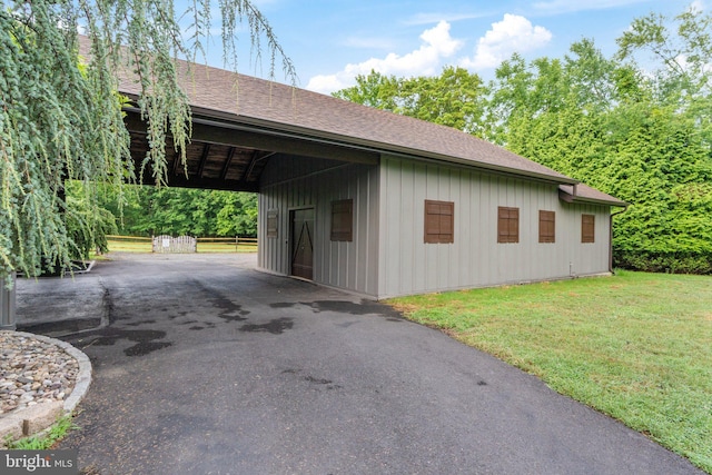 view of property exterior featuring a yard, an outbuilding, and a carport