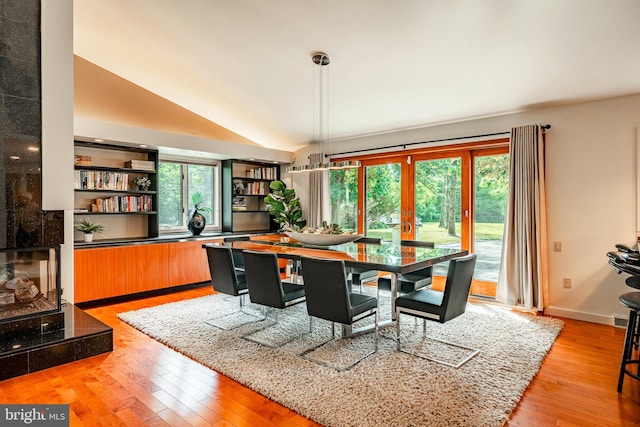 dining space with lofted ceiling and light hardwood / wood-style flooring