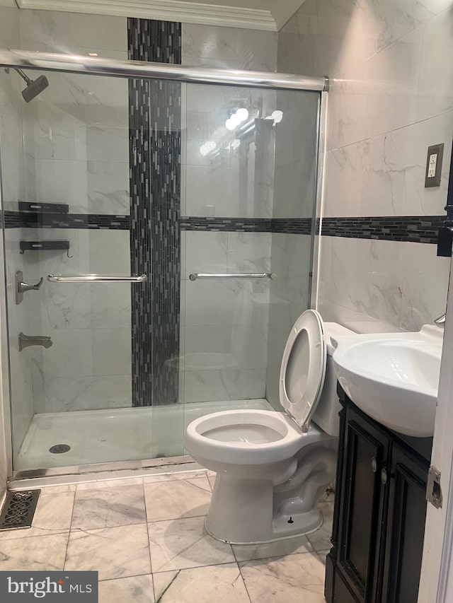 bathroom featuring an enclosed shower, ornamental molding, vanity, tile walls, and toilet