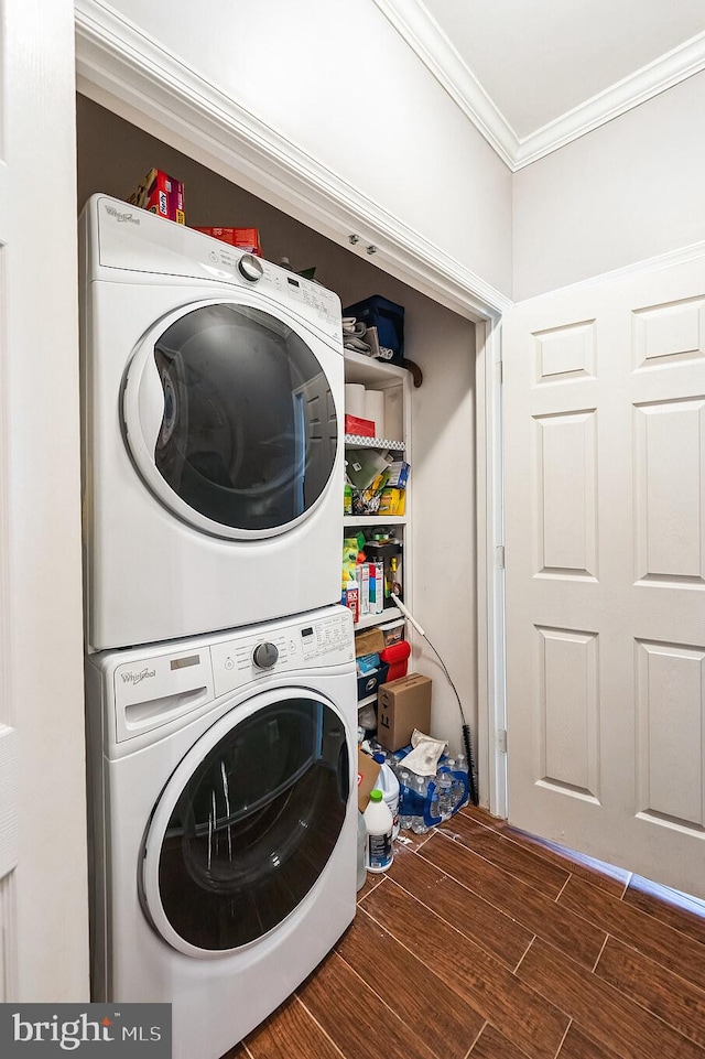 laundry area with crown molding and stacked washer and clothes dryer