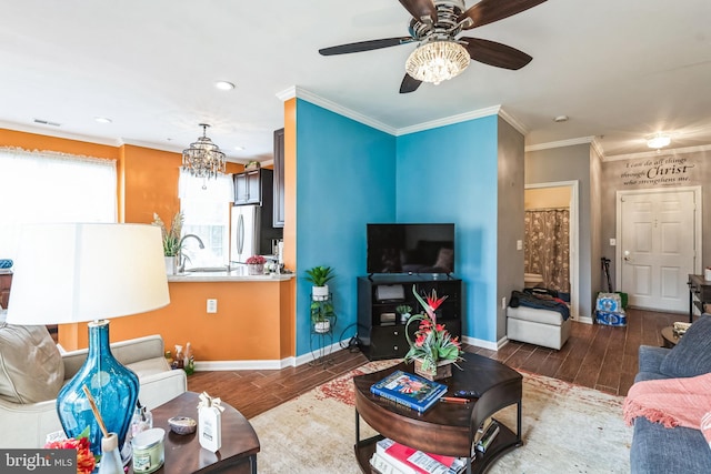 living room featuring ornamental molding, sink, and ceiling fan with notable chandelier