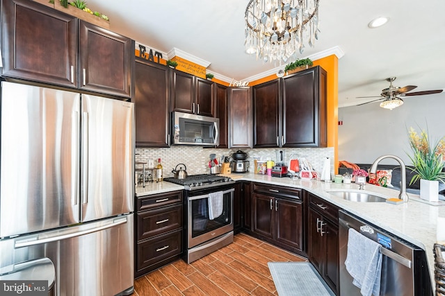 kitchen with stainless steel appliances, sink, pendant lighting, and decorative backsplash