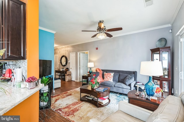 living room featuring ceiling fan, ornamental molding, and dark hardwood / wood-style floors