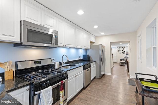 kitchen featuring white cabinetry, sink, light hardwood / wood-style flooring, and appliances with stainless steel finishes