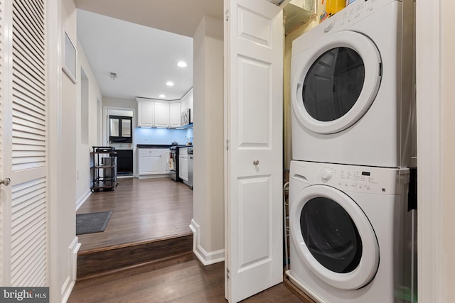 washroom with dark hardwood / wood-style floors and stacked washer and clothes dryer