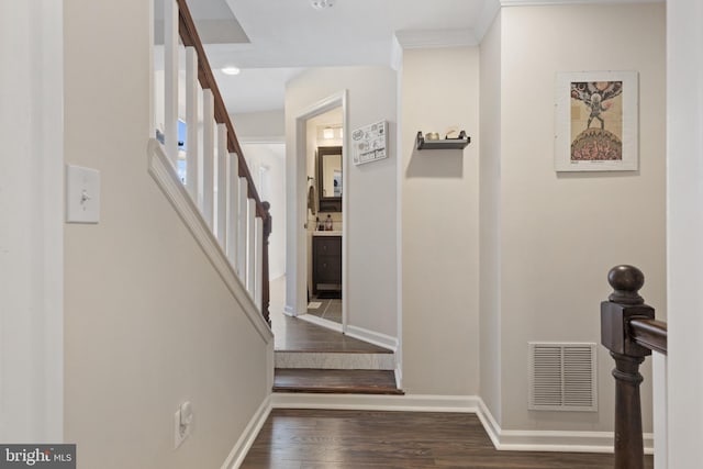 staircase with hardwood / wood-style floors and ornamental molding